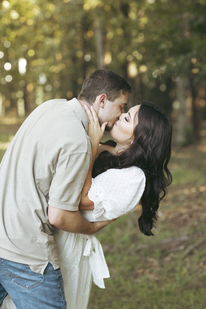 Couple kissing during a romantic proposal session in the woods of Alabama, captured by Chapman Photo Company, LLC.